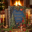 A decorative book titled "Santa's Christmas Tales" stands on a wooden surface in a cozy holiday setting. Personalized handmade  book cover is dark blue with raised illustrations of a 3D Christmas tree, bells, berries, and two deer, surrounded by pine branches, candles, wrapped gifts, pinecones, and small reindeer figurines.