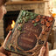 Handheld custom woodland wedding guest book featuring sculpted fall leaves and rustic tree trunk detailing.